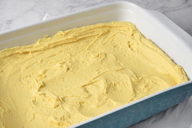unbaked gooey butter cake crust in blue baking dish ready to bake