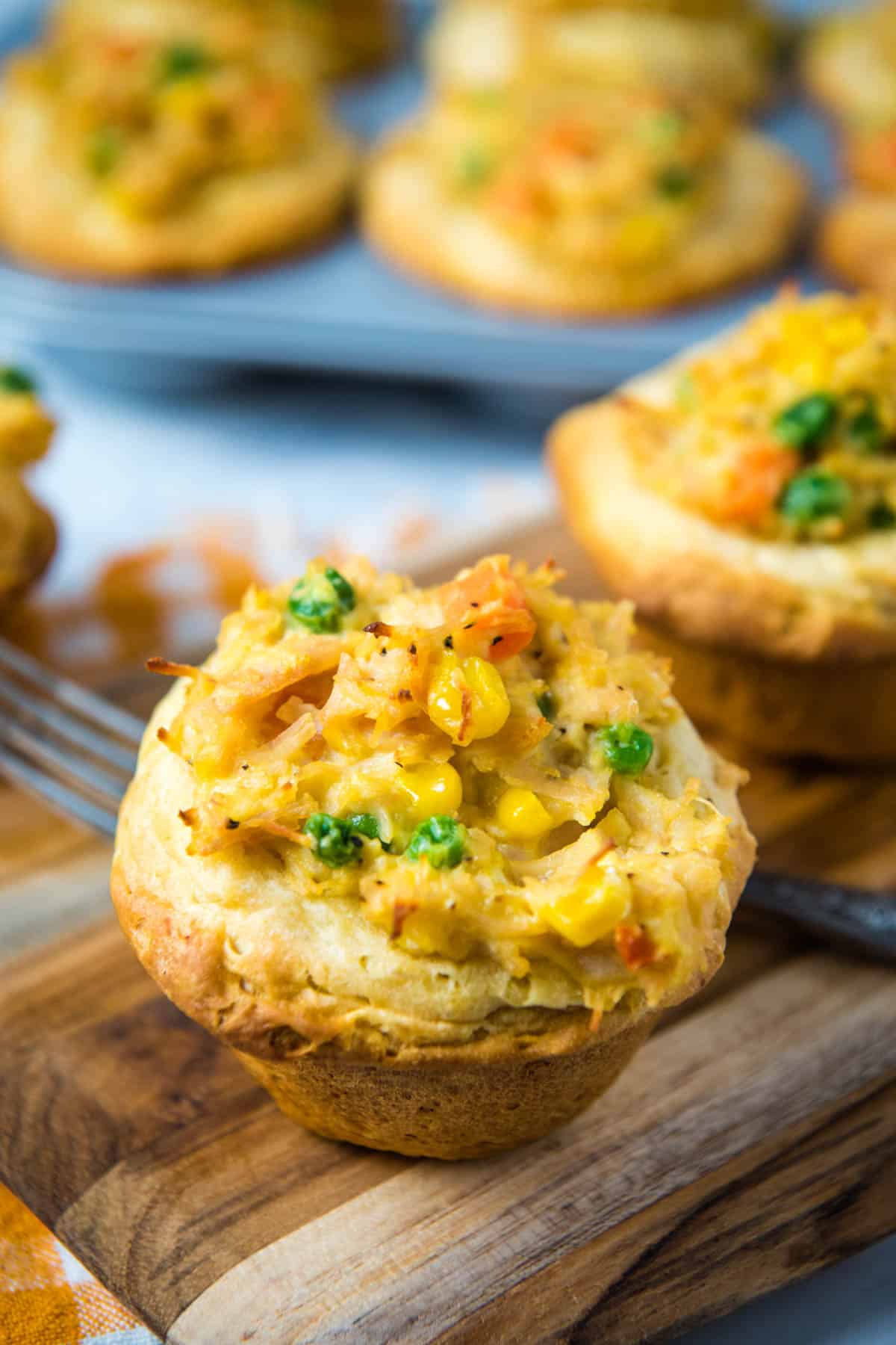 muffin tin chicken pot pie on wood cutting board with fork