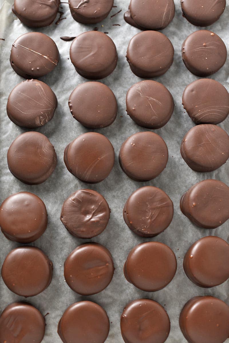 chocolate peanut butter Ritz cookies on wax paper covered baking sheet