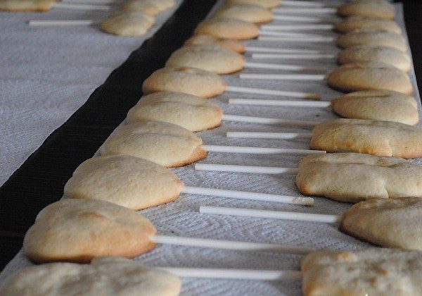 Valentine's Day cookie pops baked and ready to decorate on paper towels