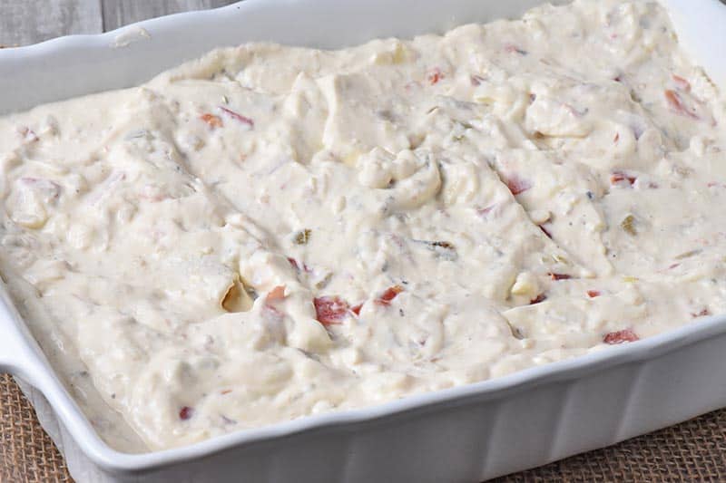 chicken enchiladas with a white enchilada sauce in white baking dish