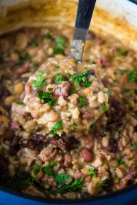 ladle full of 15 bean and ham soup over Dutch oven