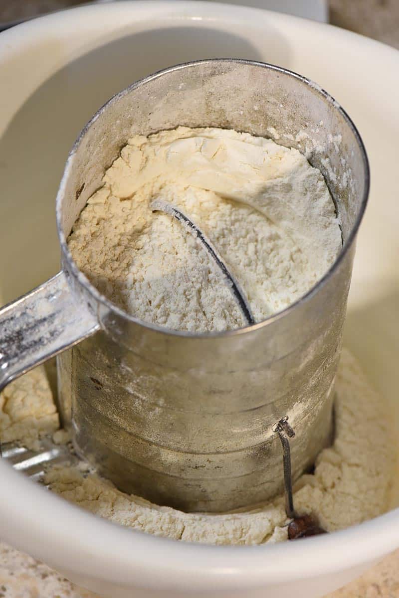 sifting dry ingredients for reindeer thumbprint cookie recipe