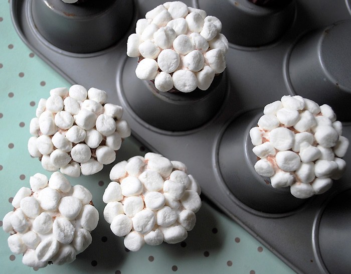 bunny butt tail cupcakes made with mini marshmallow topping on muffin tin and green and brown polka dot paper