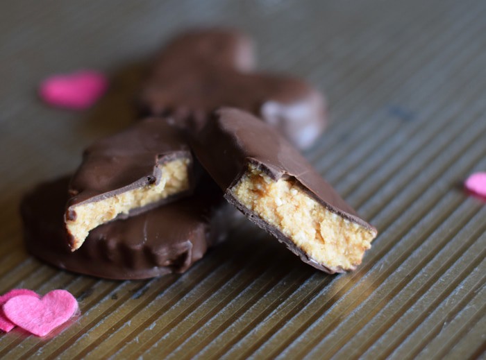 chocolate covered peanut butter hearts sliced in half on baking sheet