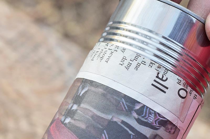 pulling newspaper pot off of tin can, making paper pot planter