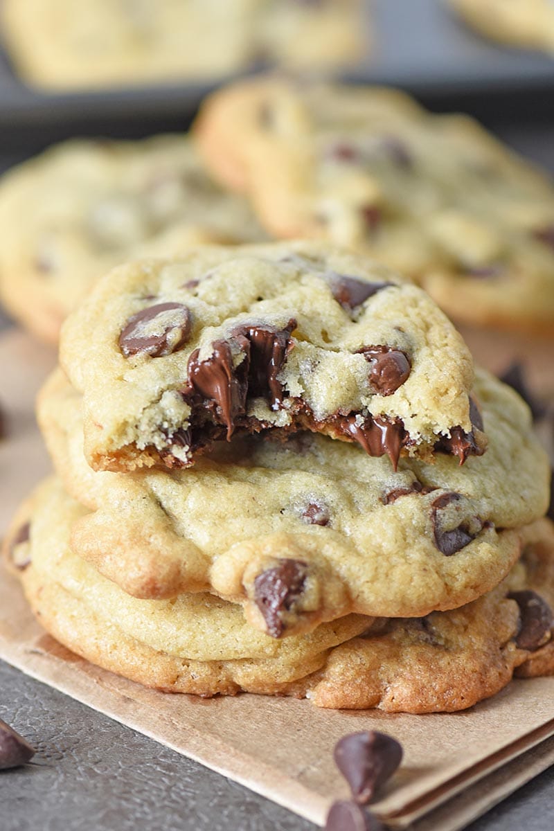 soft chocolate chip cookies stacked with melted chocolate chips and bite taken out of cookie