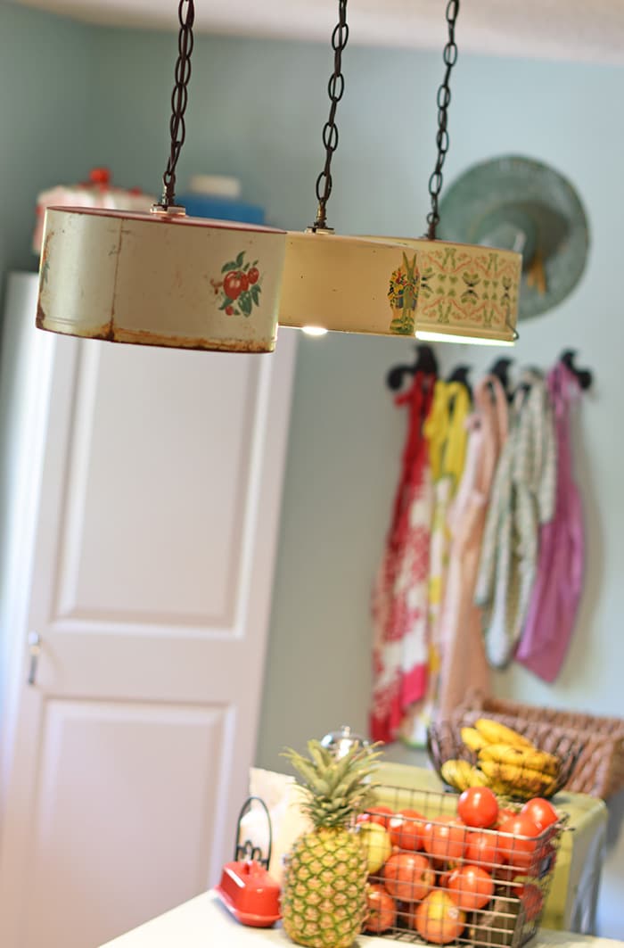 Create a farmhouse kitchen look with DIY light fixtures upcycled from vintage cake tins. How to create a charming look with affordable and simple kitchen lighting.