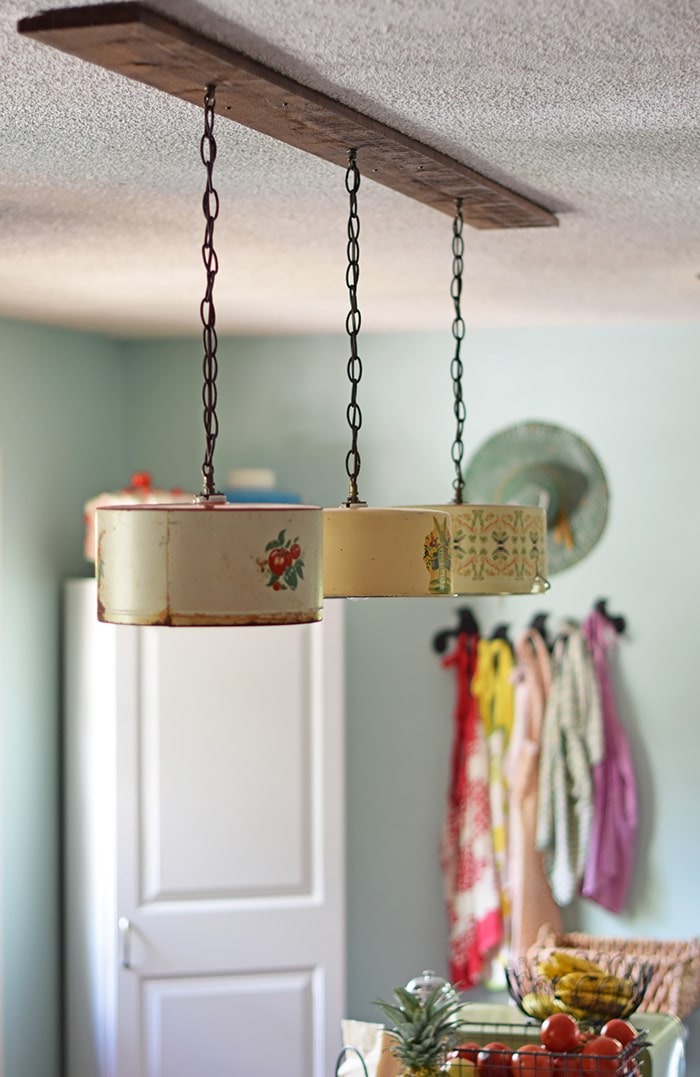 Create a farmhouse kitchen look with DIY light fixtures upcycled from vintage cake tins. How to create a charming look with affordable and simple kitchen lighting.