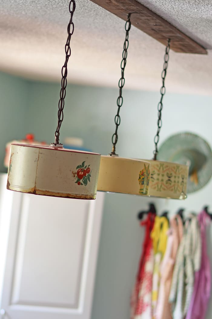 Create a farmhouse kitchen look with DIY light fixtures upcycled from vintage cake tins. How to create a charming look with affordable and simple kitchen lighting.
