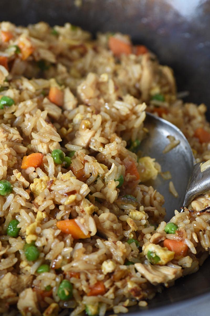 stir frying chicken fried rice in a wok with a wok spatula