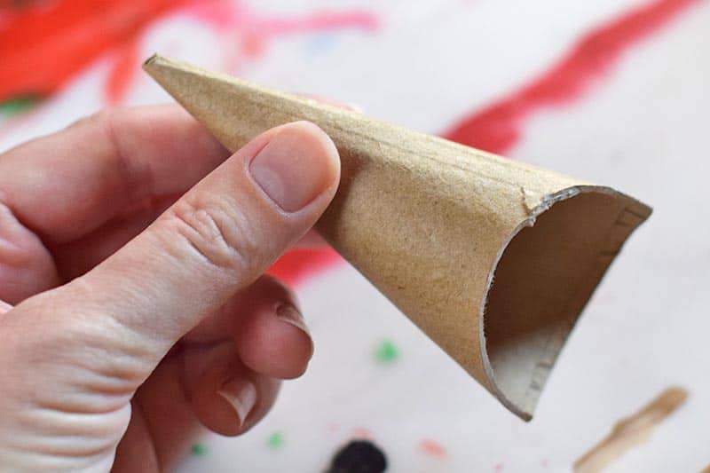 cutting rounded curve out of cardboard cone to create Triceratops horn for homemade dinosaur Valentine's day box