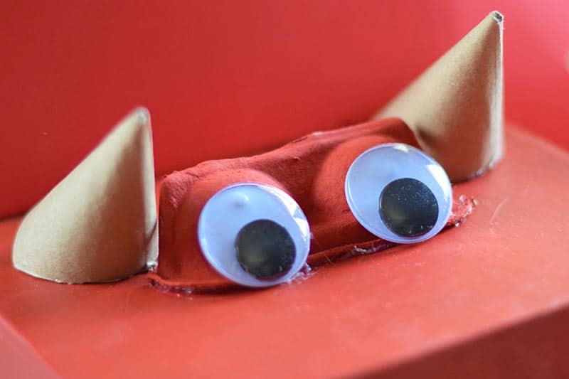glued horns in place on dino Valentine box with large googly eyes