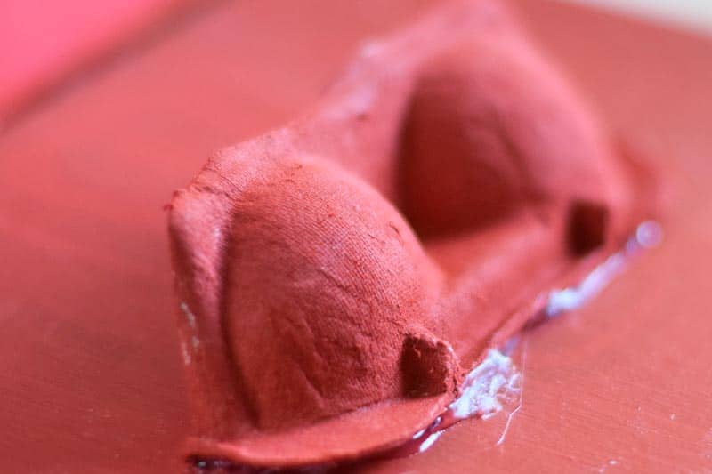 part of an egg carton painted red and glued onto a red painted shoebox