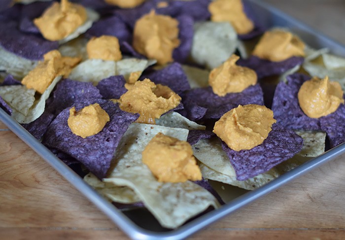 Hungry for loaded nachos and Tex-Mex but don’t feel like going out? Make the most flavorful loaded nachos with chicken and roasted red pepper hummus, along with other favorite ingredients like cheese, tomatoes, avocado, and more. Chicken and Hummus Loaded Nachos in a Sheet Pan Recipe!
