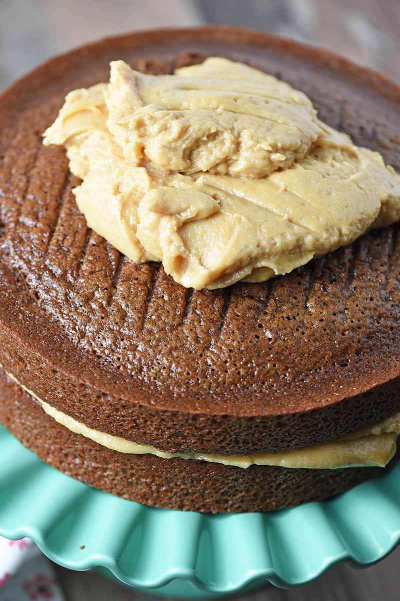 Frosting a chocolate cake with peanut butter frosting