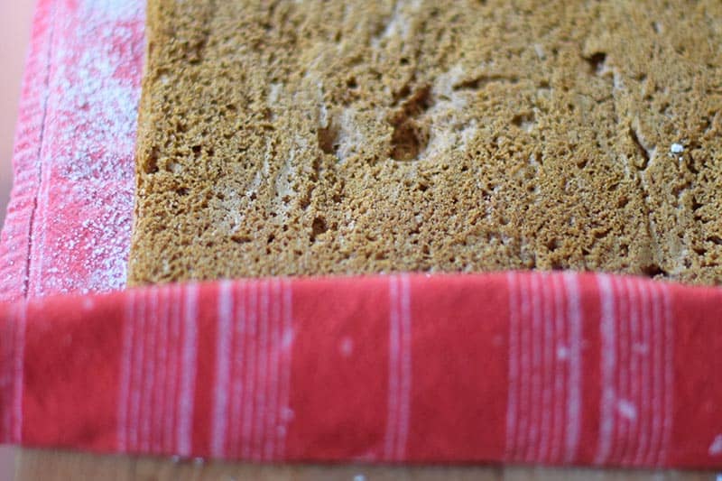 rolling pumpkin roll cake up in flour sack towel