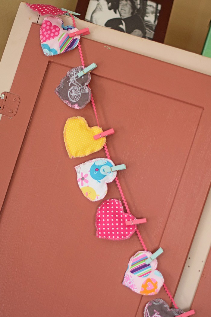 Decorate for Valentine's Day by making a super easy to sew Valentine's Day heart garland with cheap fat quarters from the fabric store. Makes the sweetest Valentine decoration and a fun craft and sewing project! 