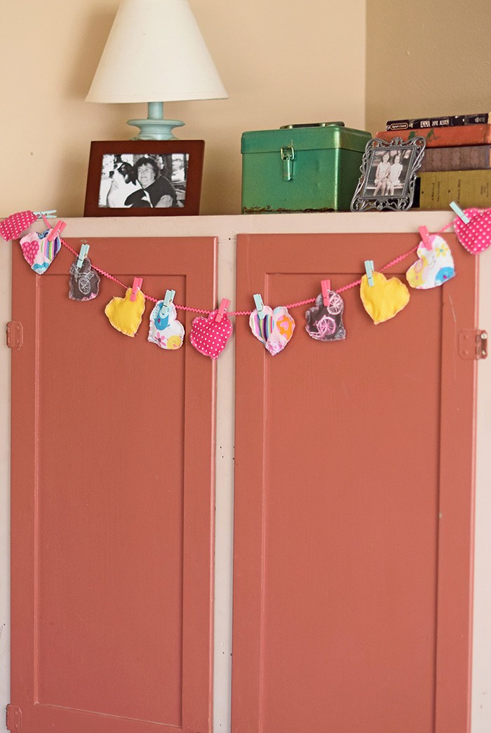 Decorate for Valentine's Day by making a super easy to sew Valentine's Day heart garland with cheap fat quarters from the fabric store. Makes the sweetest Valentine decoration and a fun craft and sewing project! 