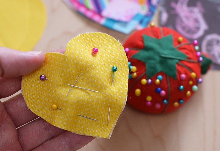 Decorate for Valentine's Day by making a super easy to sew Valentine's Day heart garland with cheap fat quarters from the fabric store. Makes the sweetest Valentine decoration and a fun craft and sewing project! 