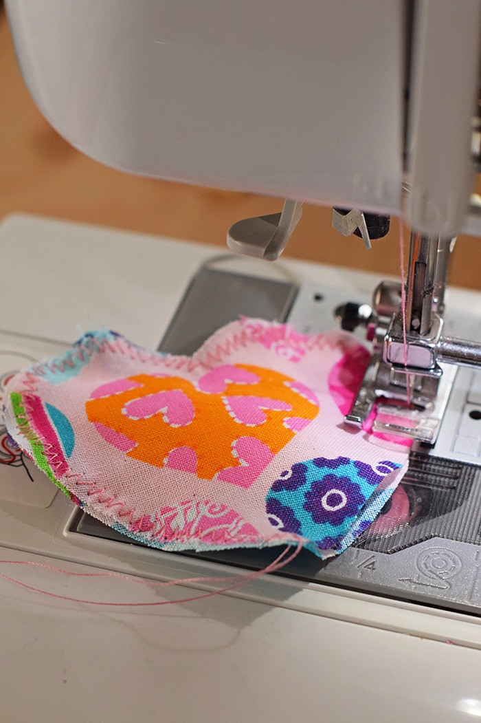 Decorate for Valentine's Day by making a super easy to sew Valentine's Day heart garland with cheap fat quarters from the fabric store. Makes the sweetest Valentine decoration and a fun craft and sewing project! 