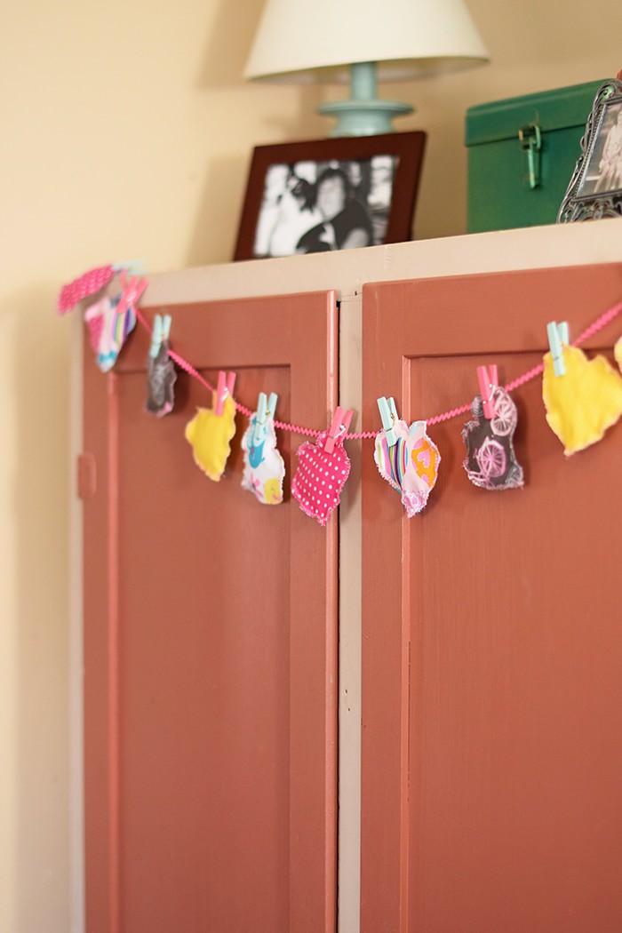 Decorate for Valentine's Day by making a super easy to sew Valentine's Day heart garland with cheap fat quarters from the fabric store. Makes the sweetest Valentine decoration and a fun craft and sewing project! 