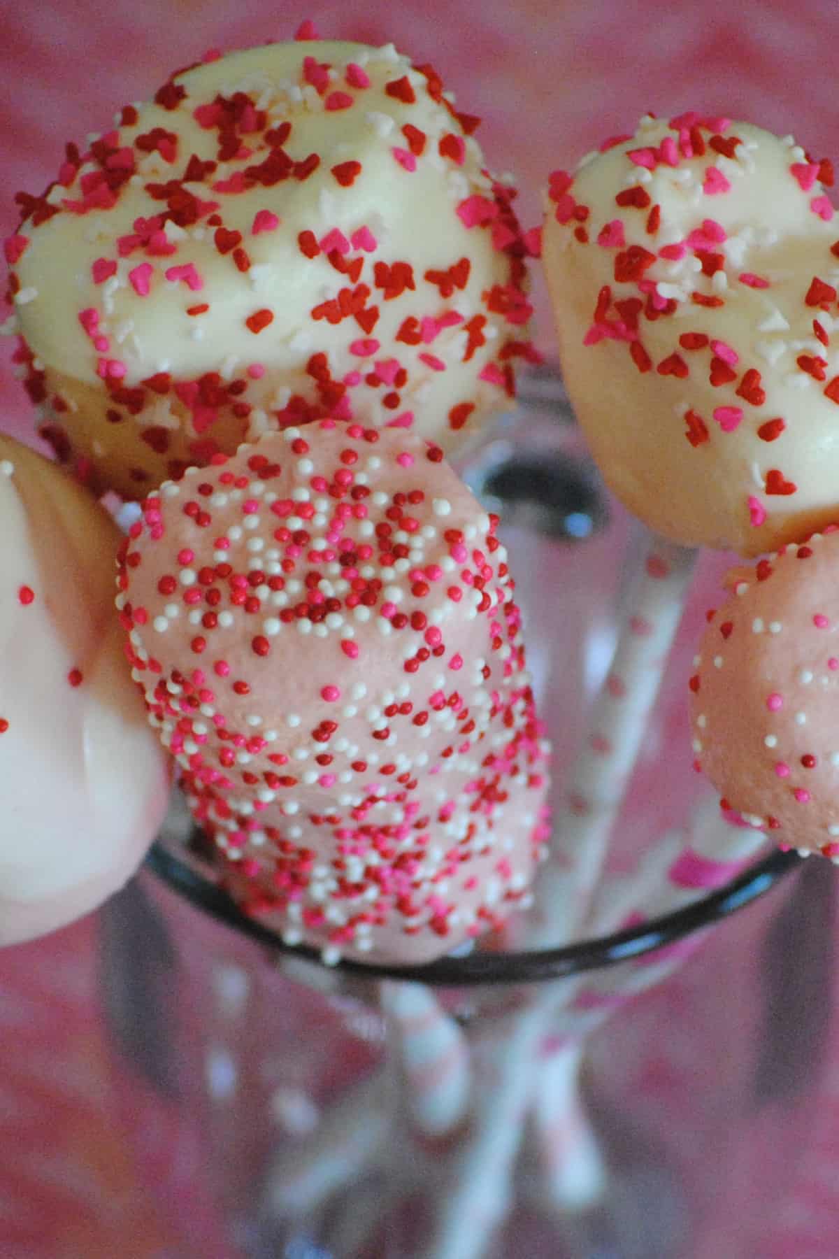 Valentine marshmallow pops with sprinkles and nonpareils in glass cup