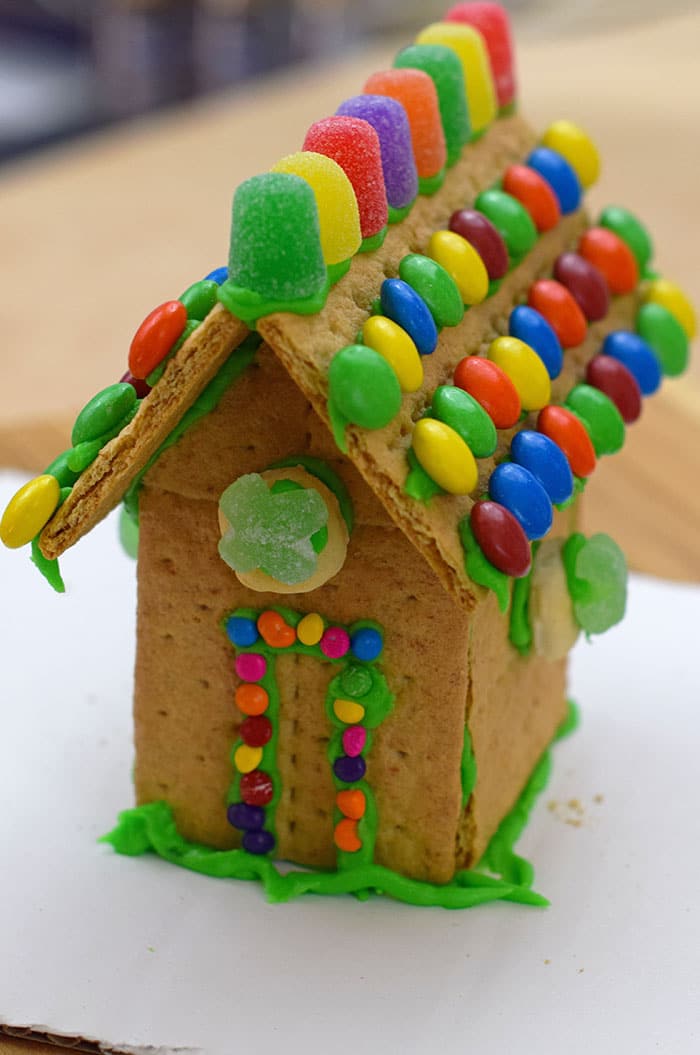 Make a fun and edible kids craft this St. Patrick's Day, a Graham Cracker Leprechaun House. Gather rainbow colored candies, Decorating Icing, and graham crackers, and you're all set!