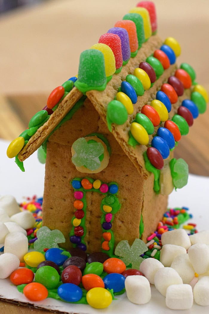 Make a fun and edible kids craft this St. Patrick's Day, a Graham Cracker Leprechaun House. Gather rainbow colored candies, Decorating Icing, and graham crackers, and you're all set!
