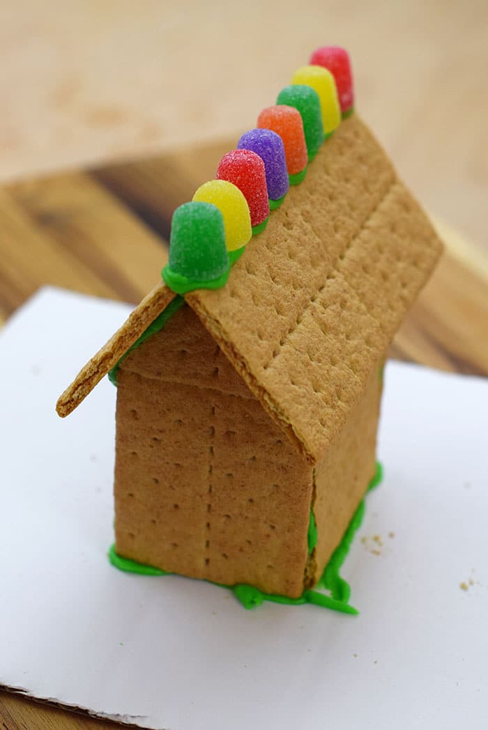 Make a fun and edible kids craft this St. Patrick's Day, a Graham Cracker Leprechaun House. Gather rainbow colored candies, Decorating Icing, and graham crackers, and you're all set!