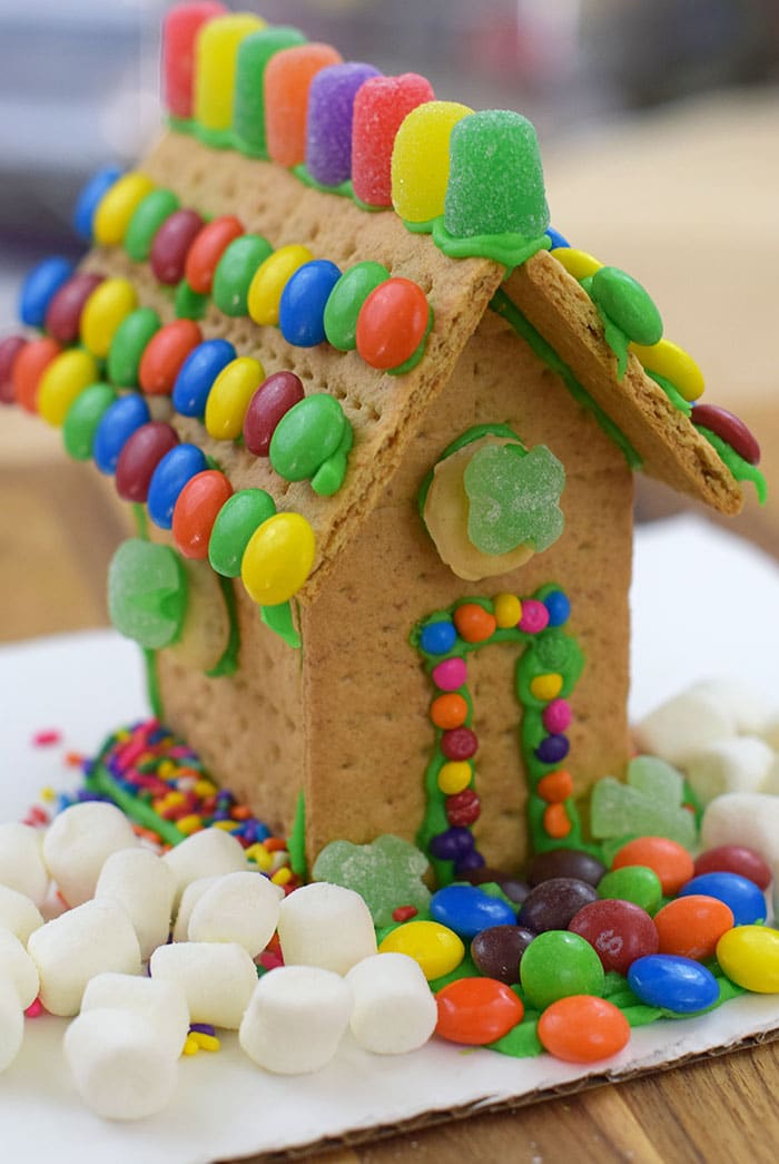 Make a fun and edible kids craft this St. Patrick's Day, a Graham Cracker Leprechaun House. Gather rainbow colored candies, Decorating Icing, and graham crackers, and you're all set!