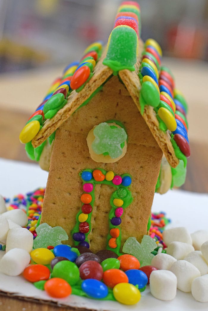 Make a fun and edible kids craft this St. Patrick's Day, a Graham Cracker Leprechaun House. Gather rainbow colored candies, Decorating Icing, and graham crackers, and you're all set!