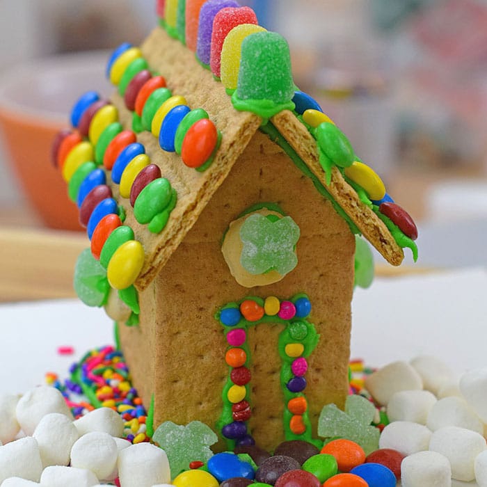 Make a fun and edible kids craft this St. Patrick's Day, a Graham Cracker Leprechaun House. Gather rainbow colored candies, Decorating Icing, and graham crackers, and you're all set!