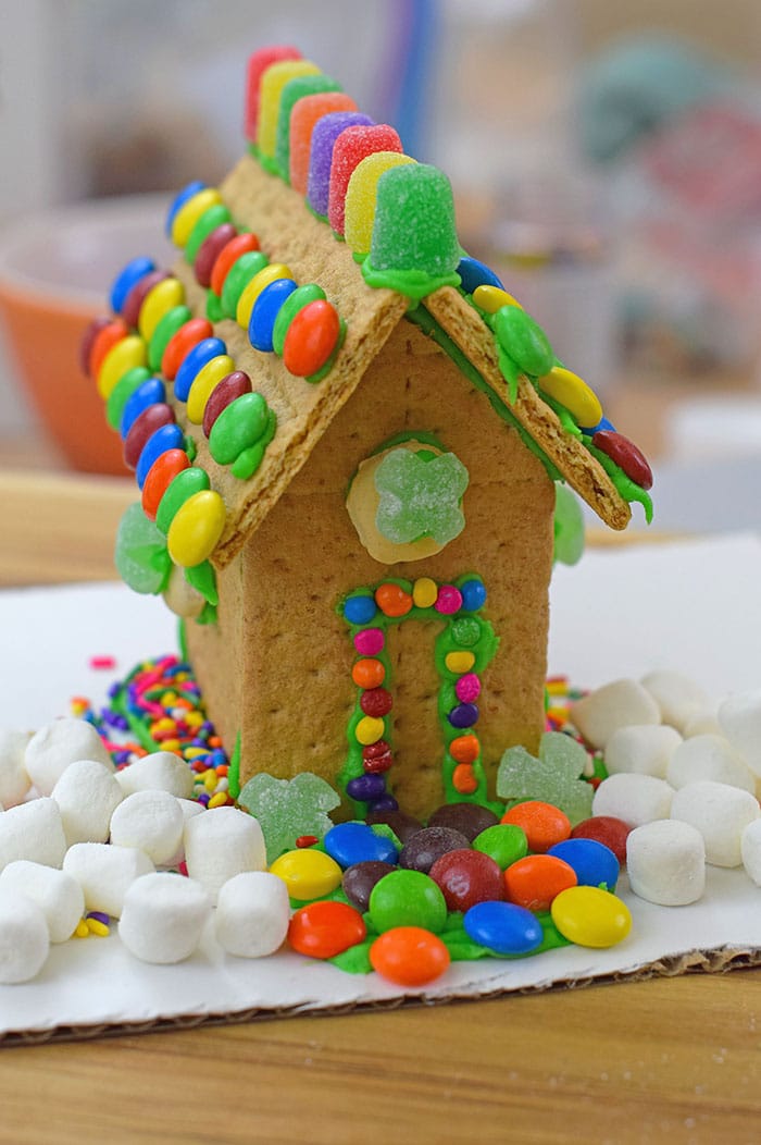 Make a fun and edible kids craft this St. Patrick's Day, a Graham Cracker Leprechaun House. Gather rainbow colored candies, Decorating Icing, and graham crackers, and you're all set!