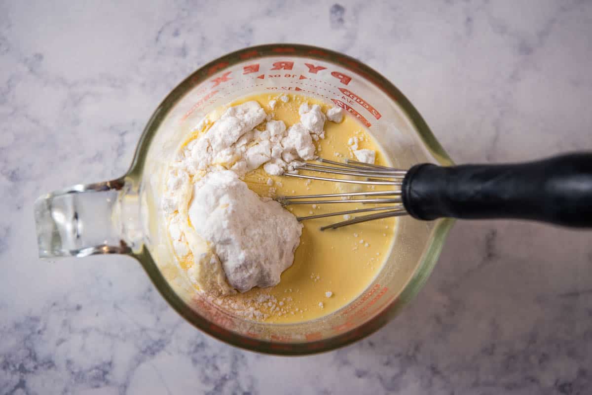 making ham gravy roux in glass measuring cup with whisk