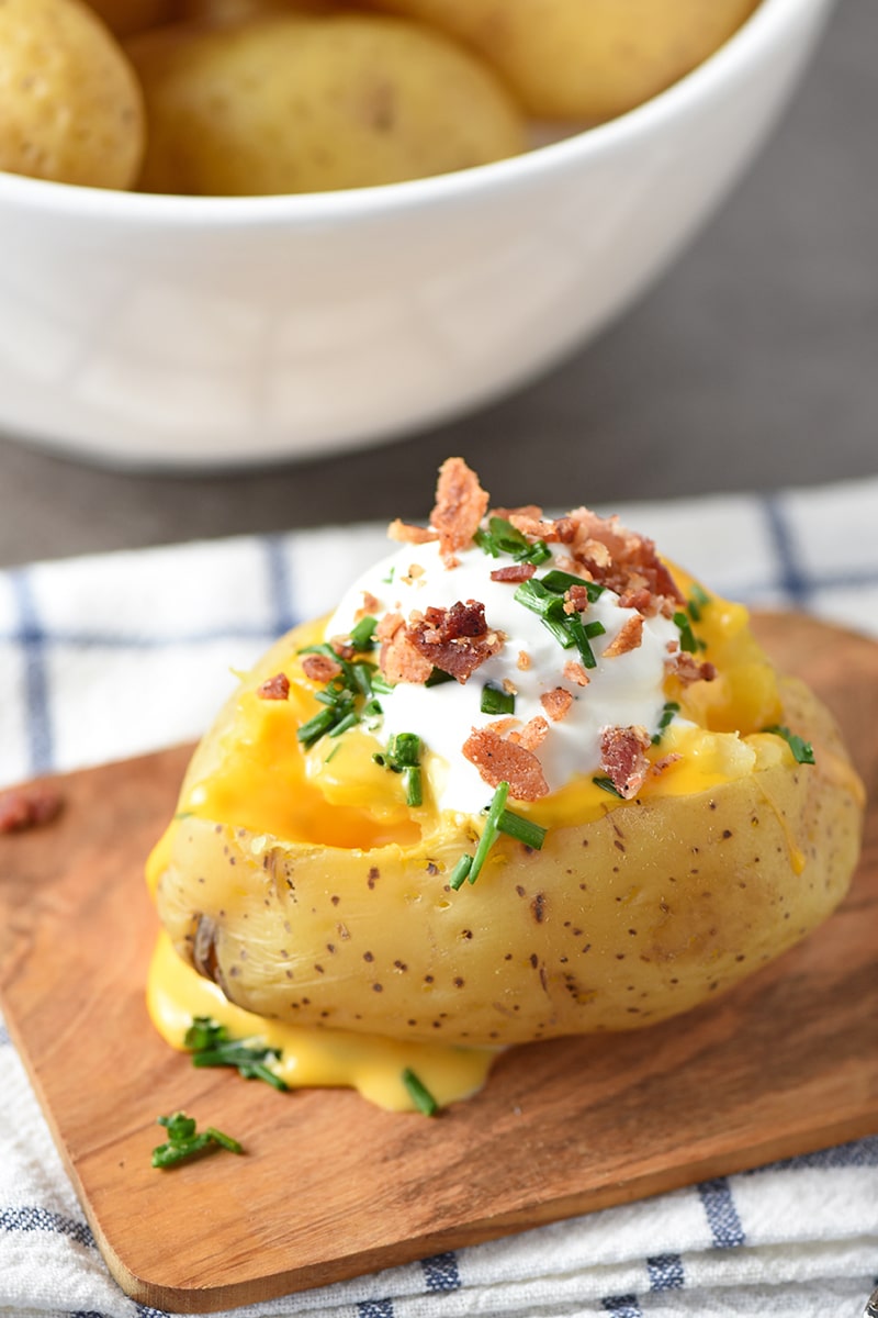 Instant Pot Baked Potatoes will be your new favorite dinner side, especially when you serve them up with all the fixings, like butter, sour cream, cheese sauce, crumbled bacon, chives, etc.