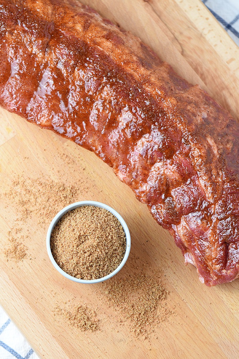 Baby back rib rub with baby back ribs on a cutting board
