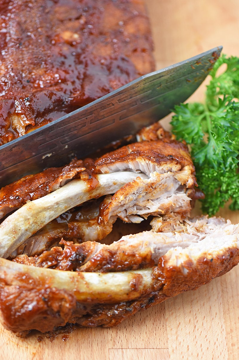 Knife Slicing Instant Pot Baby Back Ribs on a Cutting Board