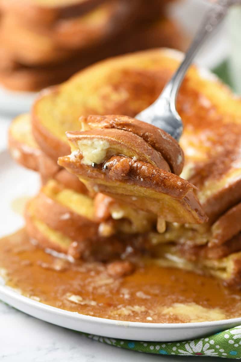 fork full of French toast with maple syrup