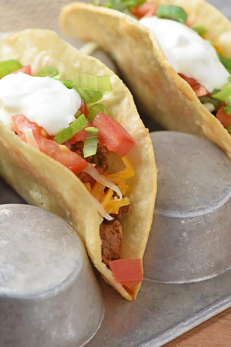 layer toppings in a fried corn tortilla shell for homemade tacos