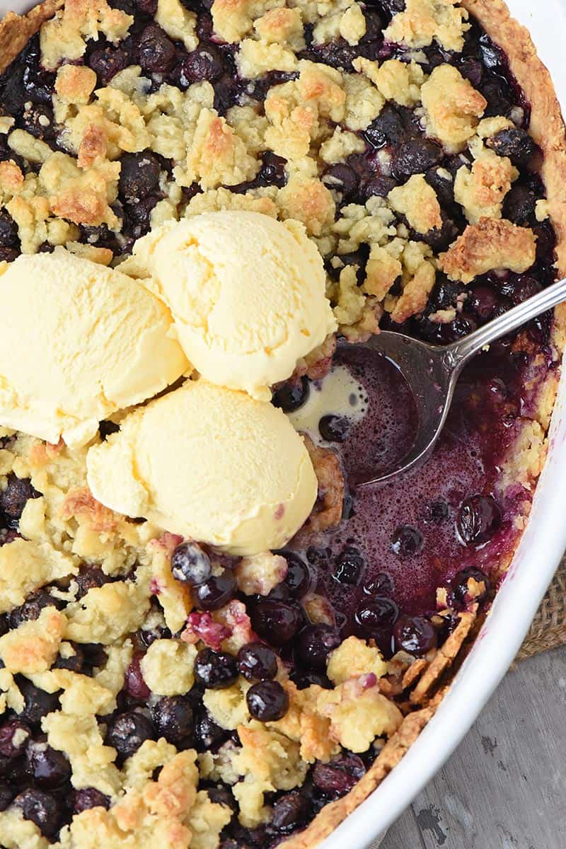 easy blueberry cobbler recipe in a baking dish with vanilla ice cream