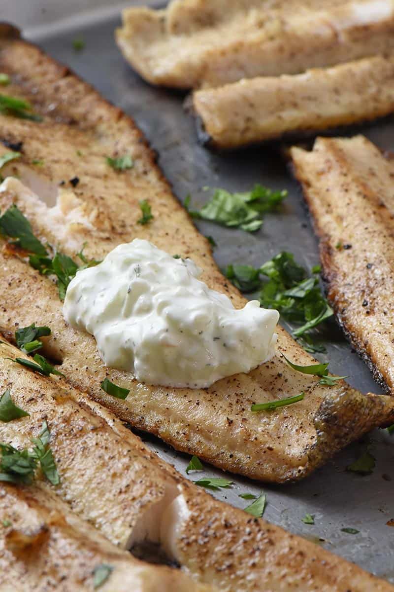 grilled fish fillets with a dollop of tzatziki sauce