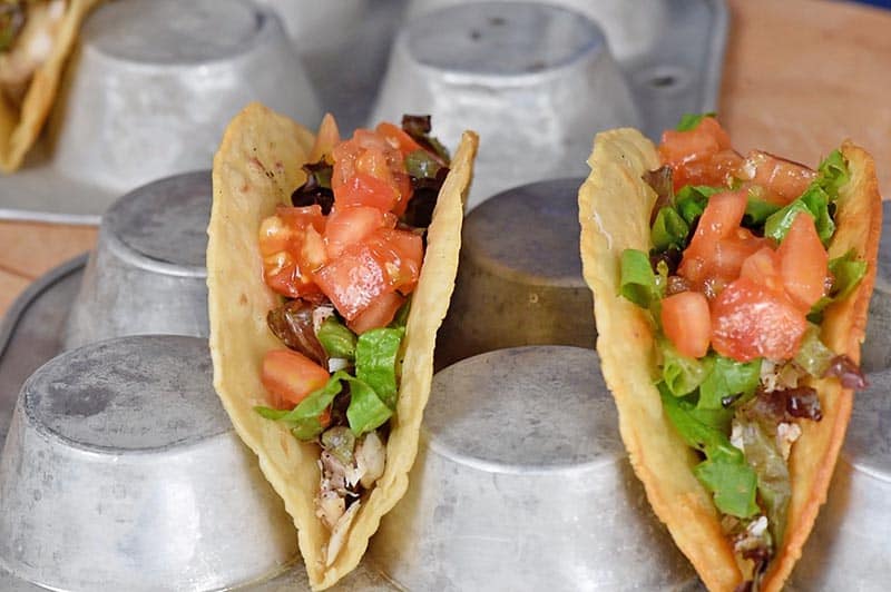 layer of tomatoes on lettuce in fish tacos
