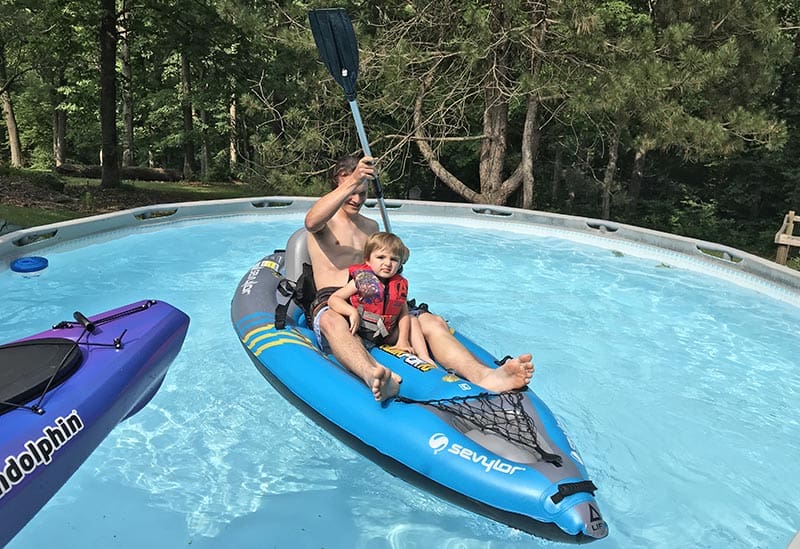 kids practicing kayaking and paddling in a swimming pool