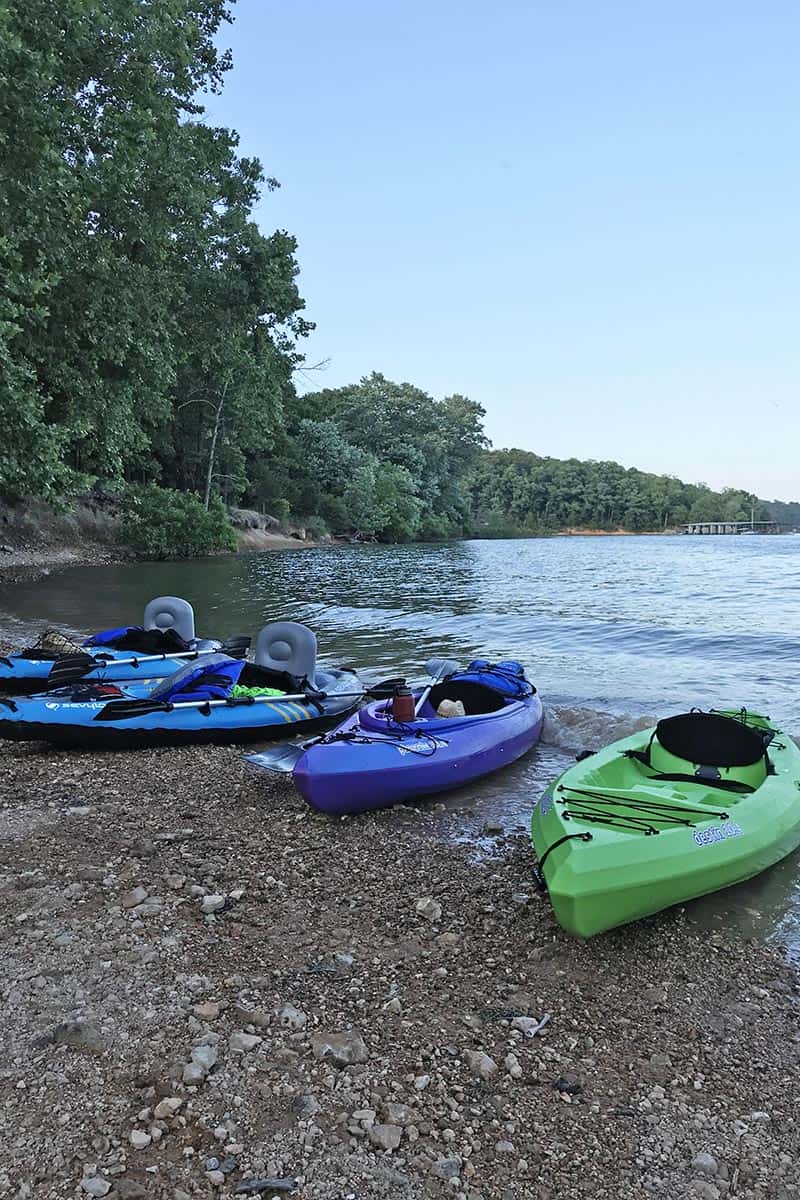 Sun Dolphin hardshell and Sevylor inflatable kayaks on beach of Beaver Lake in Northwest Arkansas