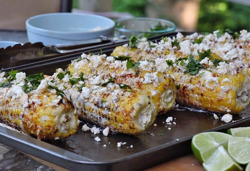 adding cilantro to mexican corn on the cob