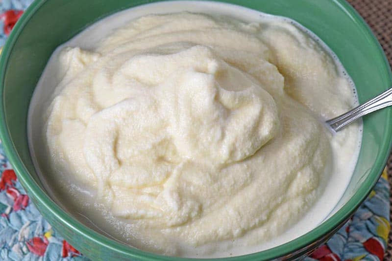 green bowl of old fashioned homemade vanilla ice cream with spoon