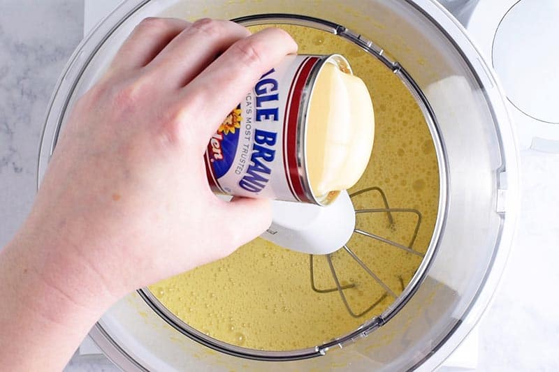 adding sweetened condensed milk to mixer to make homemade ice cream with sweetened condensed milk and whole milk