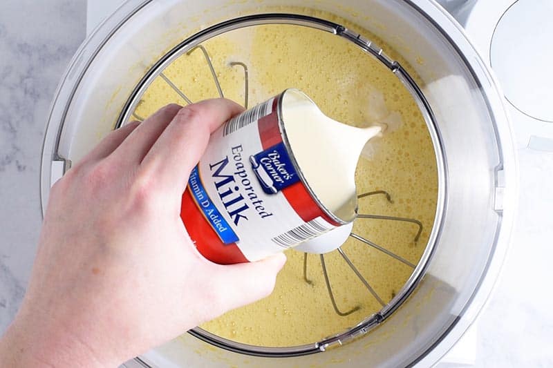 adding evaporated milk to mixture in Bosch mixer to make homemade evaporated milk ice cream