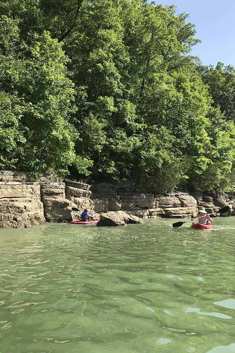 paddling kayak through boulders sticking up out of Beaver Lake